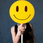 Pessoa com um emoji no rosto de sorrindo