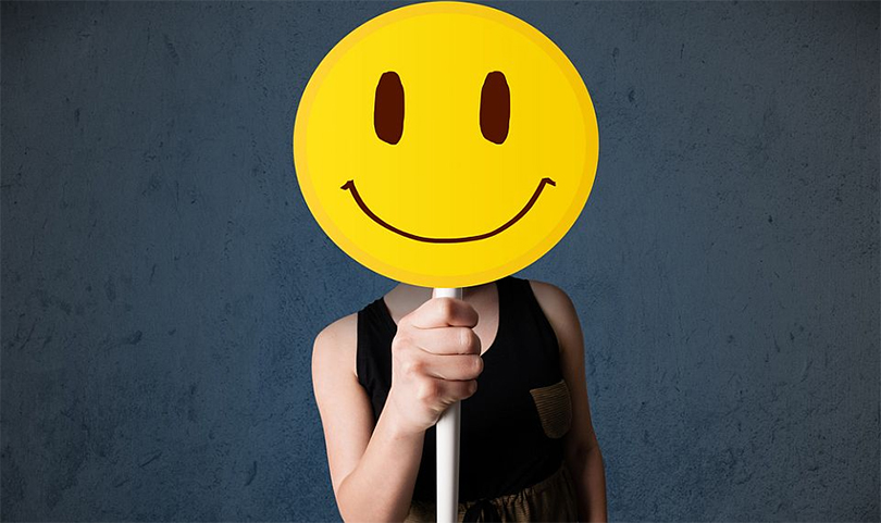 Pessoa com um emoji no rosto de sorrindo