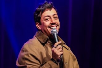 Comediante em apresentação de stand up diante de plateia em teatro lotado