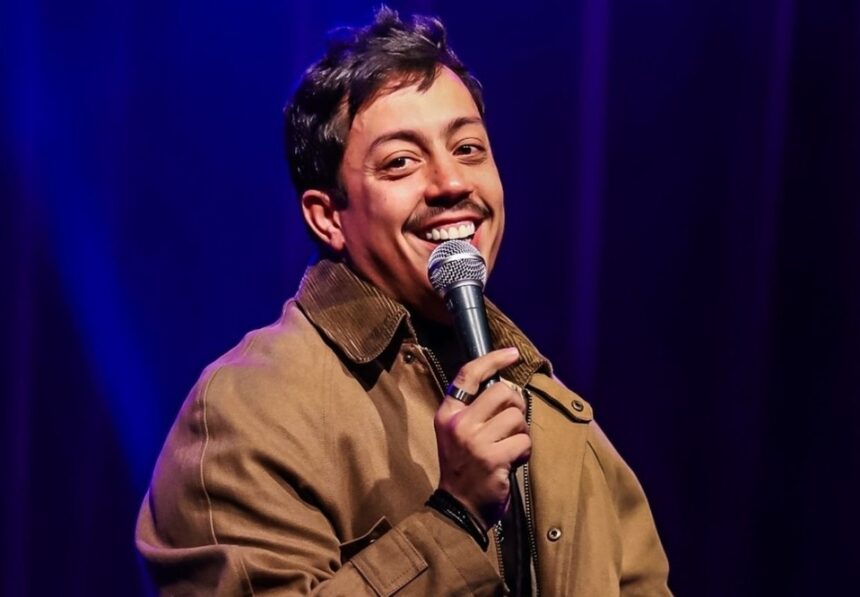 Comediante em apresentação de stand up diante de plateia em teatro lotado