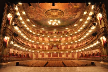 Interior do Teatro da Paz com arquitetura clássica, iluminação cênica e fileiras de assentos vazios
