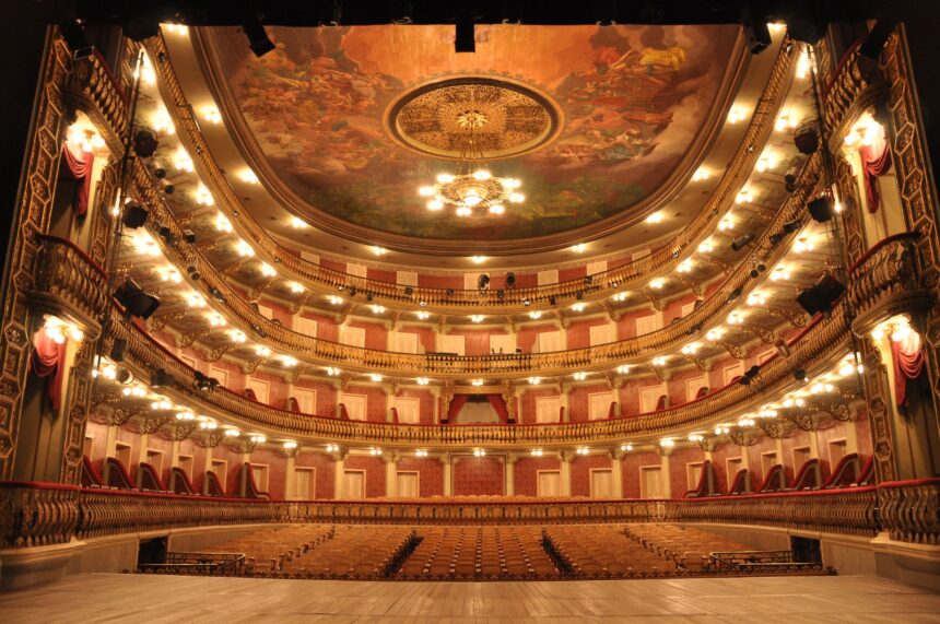 Interior do Teatro da Paz com arquitetura clássica, iluminação cênica e fileiras de assentos vazios