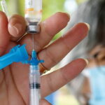 Profissional de saúde aplicando vacina em criança em unidade básica de saúde