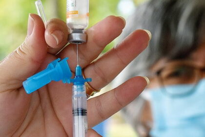 Profissional de saúde aplicando vacina em criança em unidade básica de saúde